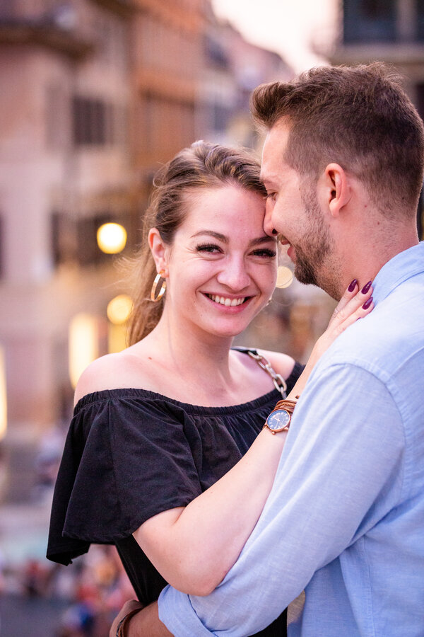Happy couple holding each other on the Spanish Steps during their proposal phtoo session in Rome