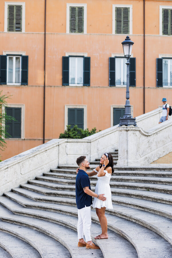 Newly-engaged couple holding each other on the Spanish Steps in Rome