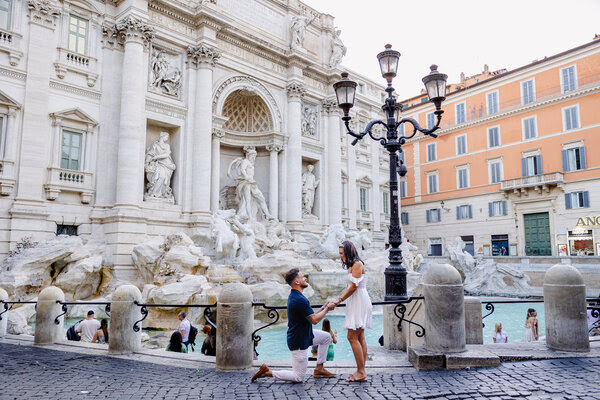 Couple during their surprise marriage proposal in Rome at the Trevi Fountain at sunrise