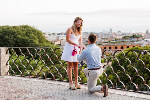 Elegant couple during their Surprise wedding proposal on the Terrazza Belvedere at sunset in the Eternal City