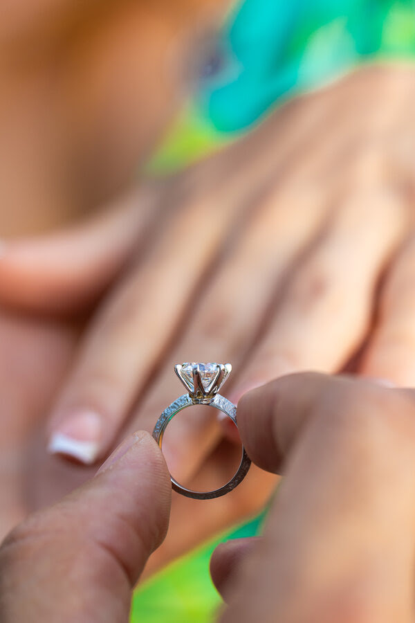 Close-up of diamond engagement close to a woman's hand