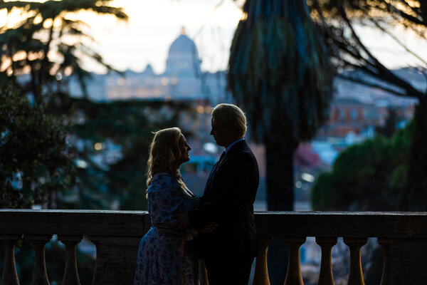 Newly-engaged couple holding each other during their surprise proposal photoshoot with the Vatican in the background