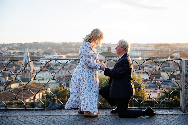 Couple during their surprise proposal on the Terrazza Belvedere in Rome at sunset
