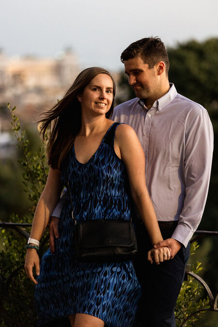Newly-engaged couple posing for the camera during their engagement photo session at sunset on the Terrazza Belvedere in Rome