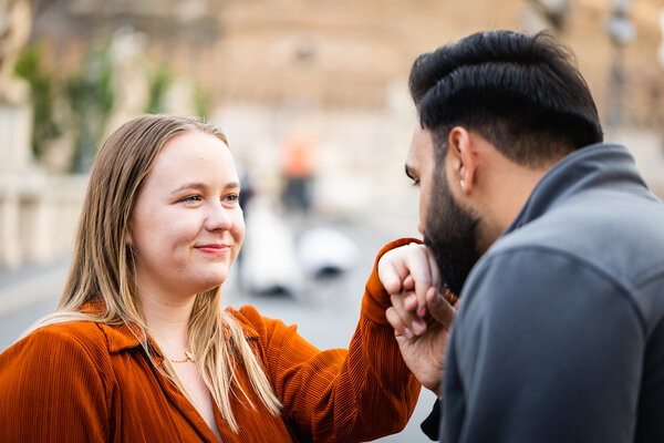 Fiancé kissing his fiancée hand during their surprise wedding proposal photo shoot in Rome