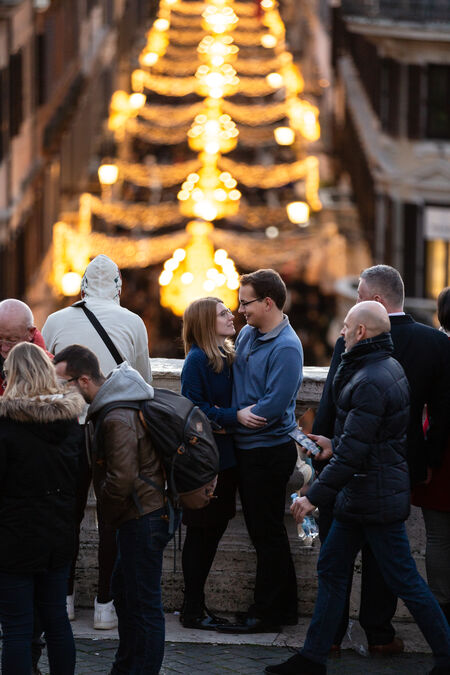 Newly-engaged couple looking at each on the Spanish Steps during the Christmas festivities