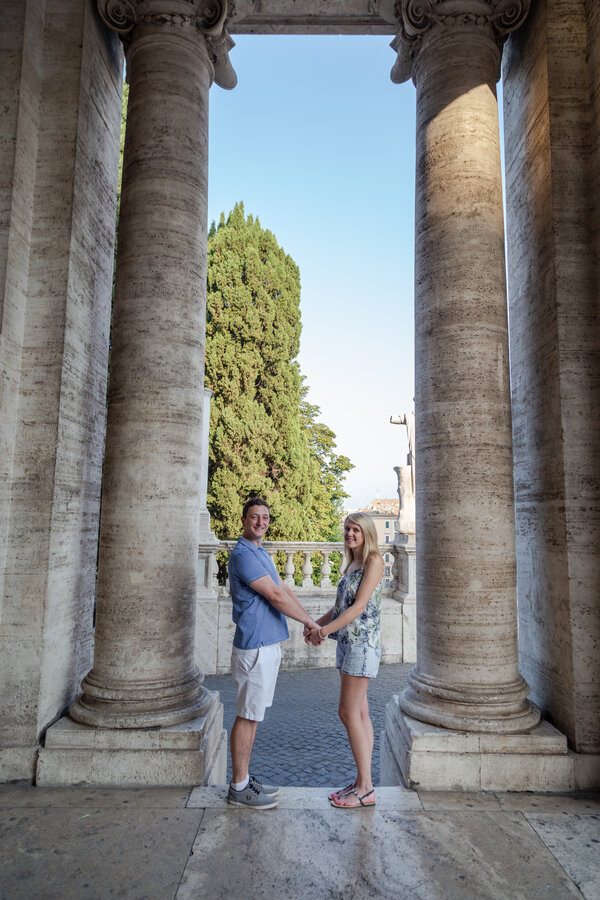 Newly-engaged couple holding hand at the Capitoline Hill while on their engagement photo session in Rome