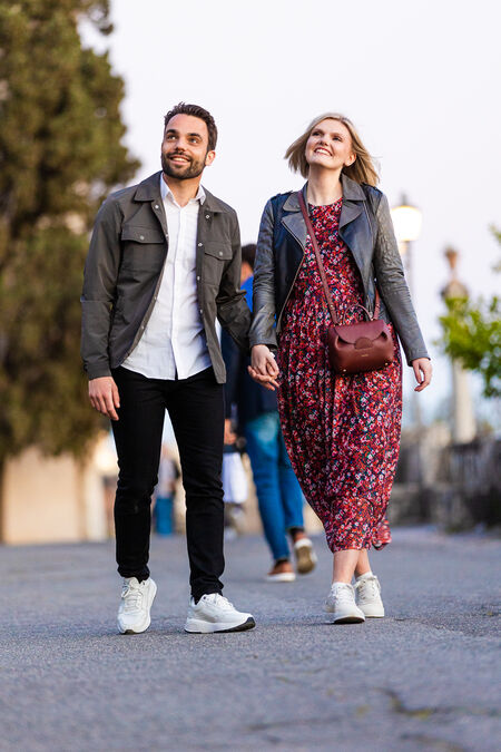 Ecstatic newly-engaged couple walking hand in hand at the Terrazza Belvedere in Rome