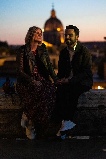 happy couple smiling in the beautiful golden hour with the Eternal City in the background