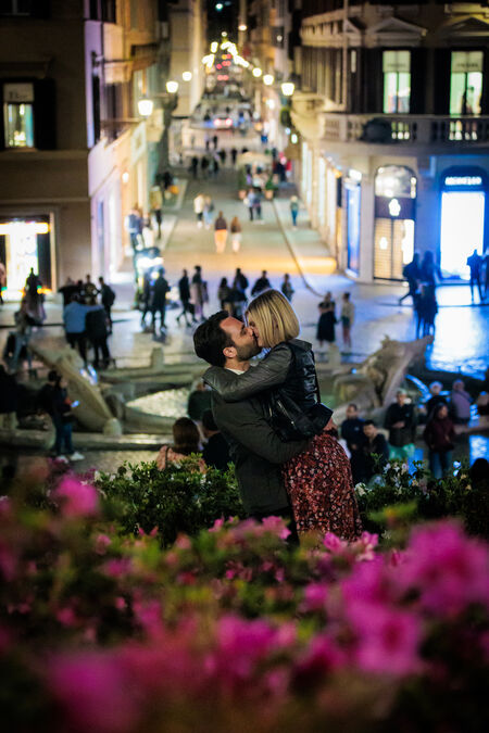 Happy couple kissing each other on the Spanish Steps at night