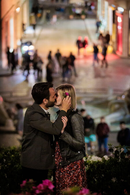 Romantic couple kissing on the Spanish Steps in Rome at night
