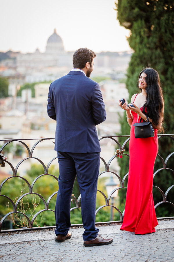Fiancée giving her fiance his engagement ring on the Terrazza Belvedere in Rome