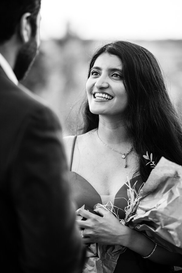 Elegant finacée smiling at her fiance while holding a bouque of flowers