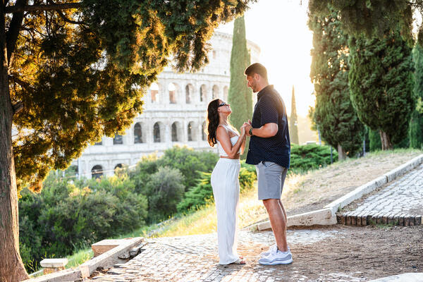 Couple holding hands during a declaration of love moments before a wedding proposal with the Colosseum in the background