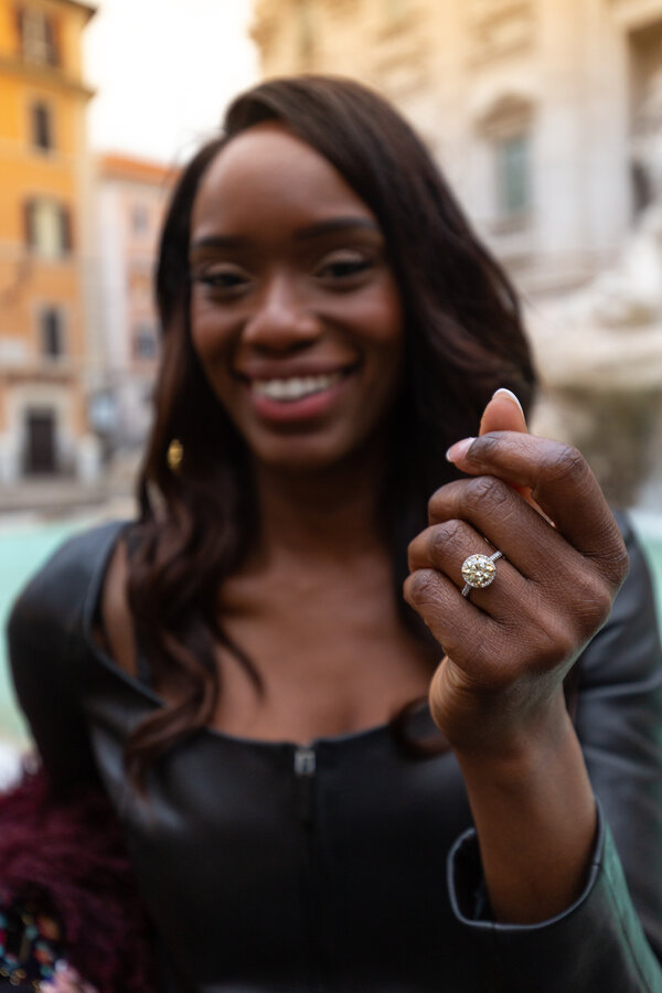 Girl showing off her engagement ring at the Trevi Fountain during a proposal photo shoot