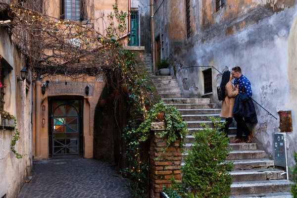 Couple kissing on staircase while on their engagement photo session in Rome