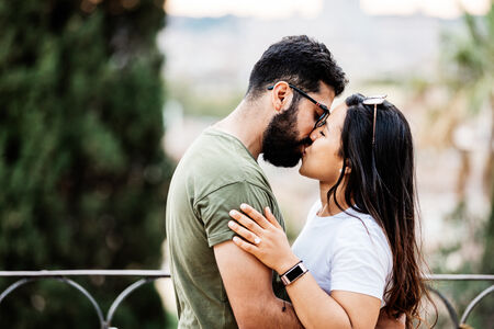 Newly-engaged couple kissing passionately at the Pincio Gardens in Rome