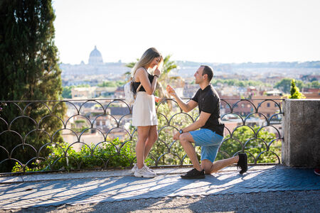 Hamed offering the engagement ring during their surprise proposal photo shoot on the Terrazza Belvedere in Rome