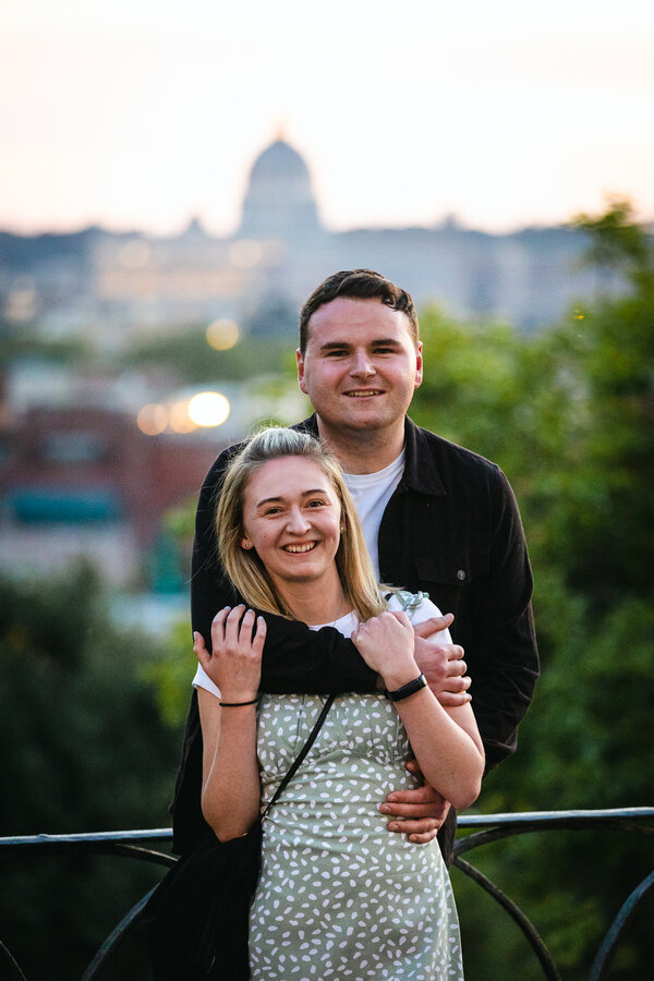Newly-engaged couple both smiling for the camera during a surprise proposal photoshoot in Rome