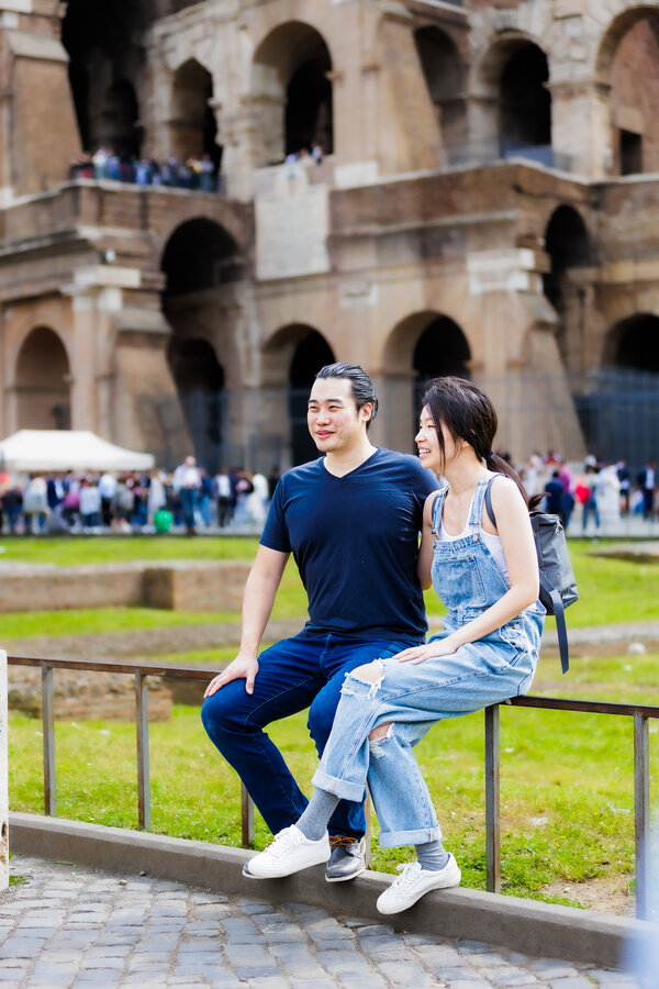 Newly-engaged couple sitting near the Colosseum