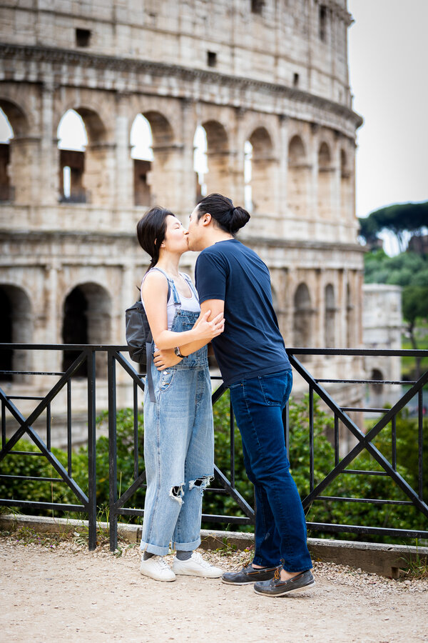 Newly-engaged couple kissing at the Giardinetto del Monte Oppio with the Colosseum in the background