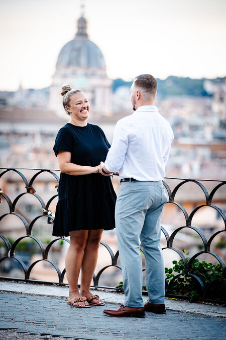 Couple holding hands on the Terrazza Belvedere moments before their surprise wedding proposal in Rome