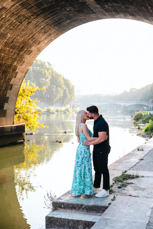 Newly-engaged couple on the Tiber riverbank in Rome during their engagement photoshoot in Rome