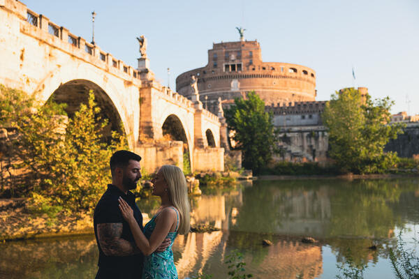 Newly-engaged couple on the Tiber riverbank in Rome during their surprise wedding proposal photoshoot in Rome
