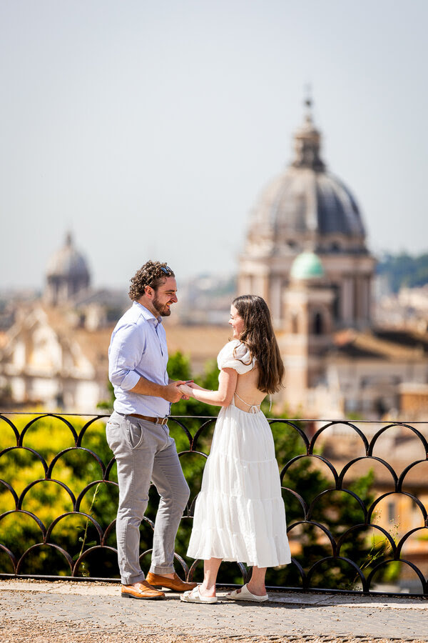 Couple holding hands at the Terrazza Belvedere during their surprise proposal photo shoot in Rome
