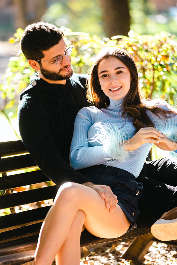 Newly-engaged couple on a bench in Villa Borghese in Rome during their engagement photoshoot in Rome