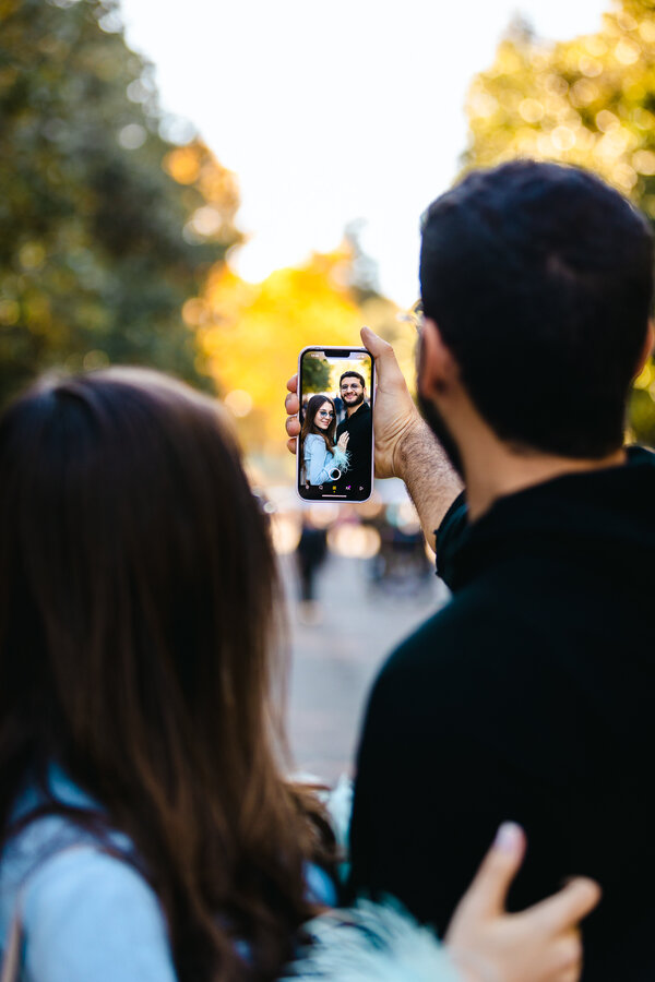 Newly-engaged couple taking a selfie during their engagement photoshoot in Villa Borghese in Rome