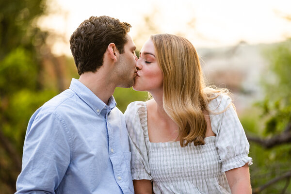 Beautiful newly-engaged couple kissing on the Pincian Hill at sunset