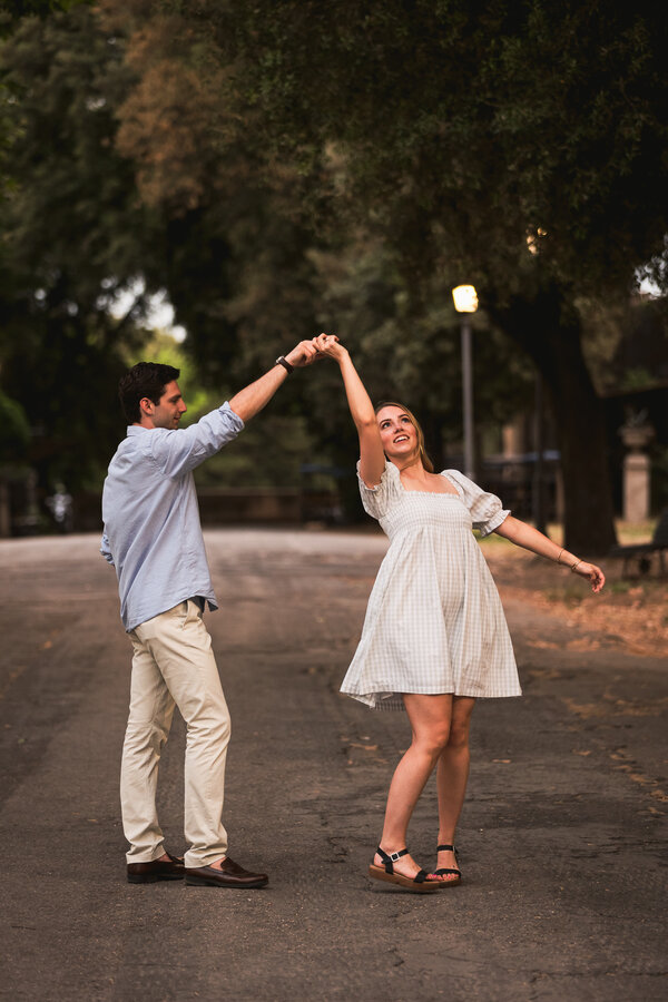 Newly-engaged couple dancing during their surprise proposal photo shoot at the Pincio Gardens