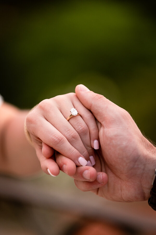 Holding hands with engagement ring during surprise proposal photo session in Rome