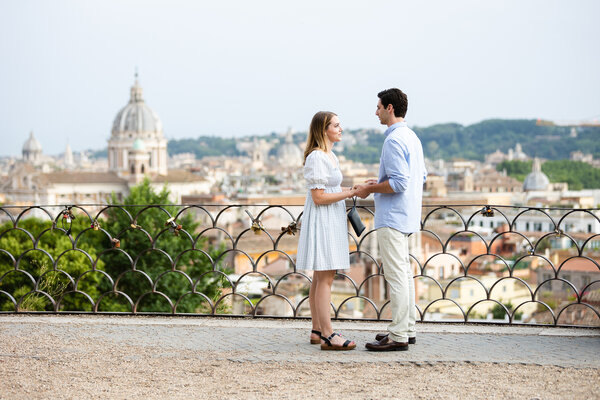 Couple standing on the Pincian Hill against the Eternal City at sunset as a backdrop
