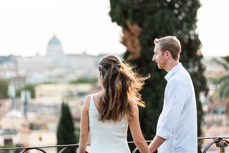 Couple holding hands on the Terrazza Belvedere before sunset during their surprise marriage proposal photo session in Rome