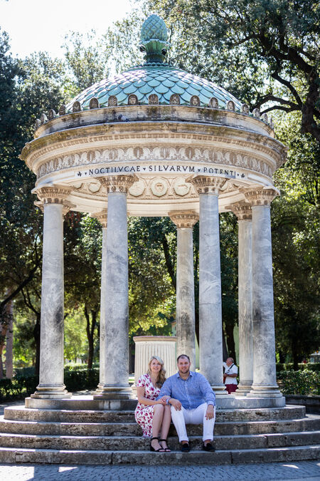 Couple sitting at the Temple of Diana in Villa Borghese Gardens during their Proposal Photo Session in Rome