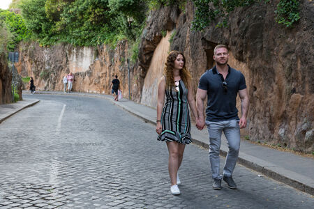 Couple walking hand in hand along Via Monte Tarpeo, Capitoline Hill, Rome