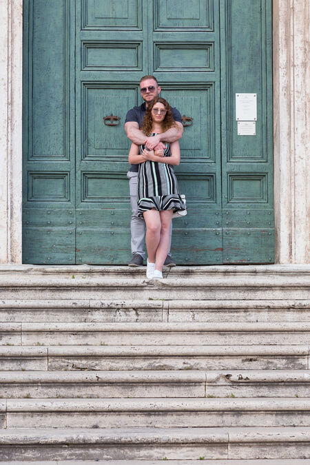 Future husband and wife in a sweet embrace at the top of the stairs to Chiesa dei Santi Luca e Martina
