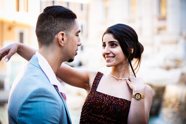 Happy newly-engaged couple celebrating at the Trevi Fountain in Rome