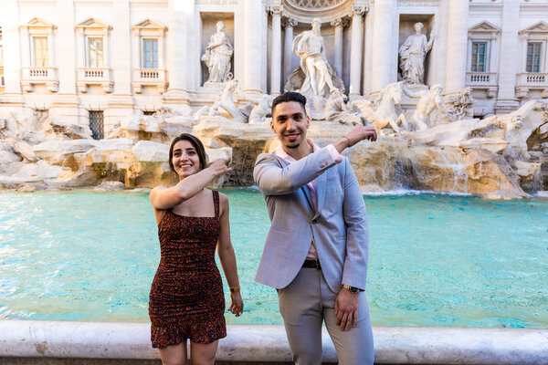 Newly-engaged couple while they are throwing a coin wishing to come back to the Eternal City