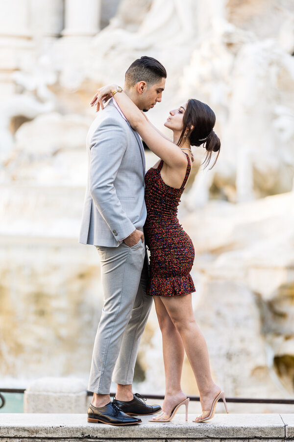 Newly-engaged couple during their surprise proposal photo shoot at the Trevi Fountain