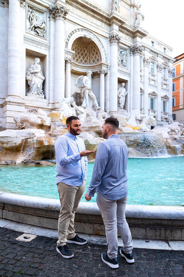 Couple picking the coins before tossing them into the Trevi Fountain