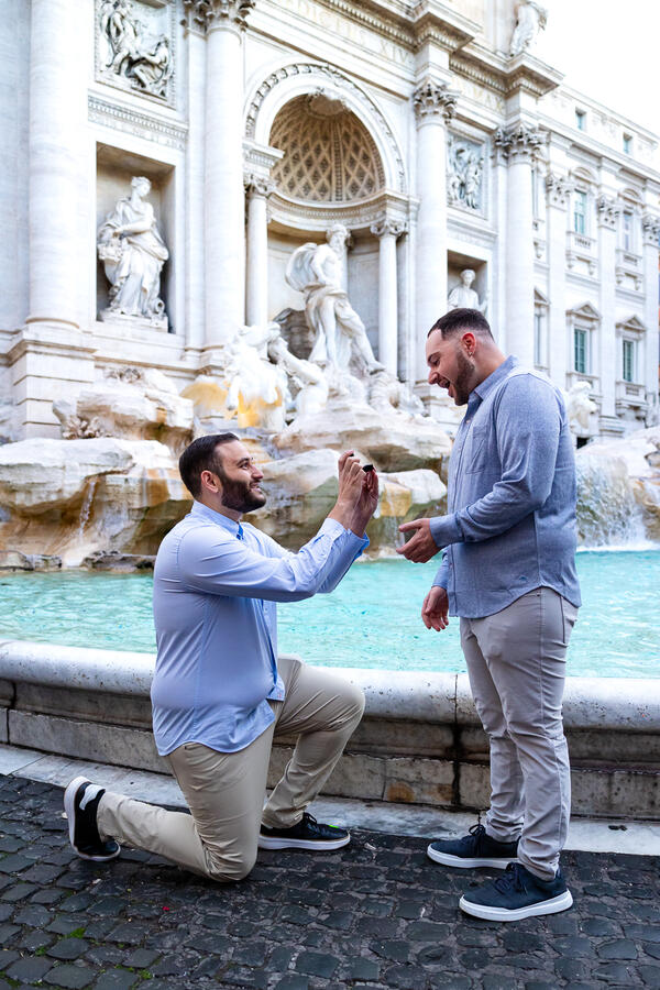 Romantic same-sex marrigae proposal by the Trevi Fountain at sunrise in Rome