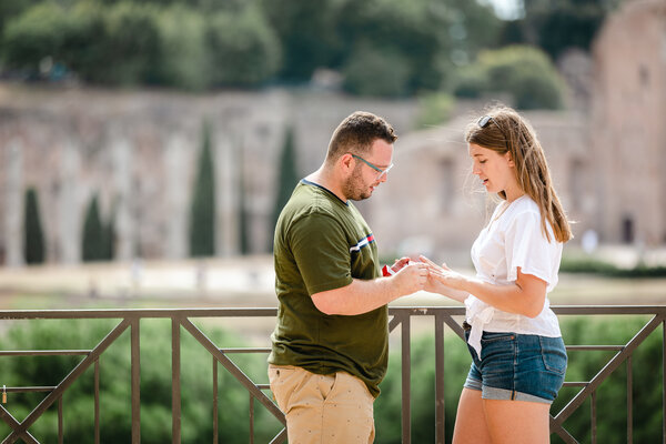 Putting on the engagement ring during a proposal photo shoot in Rome