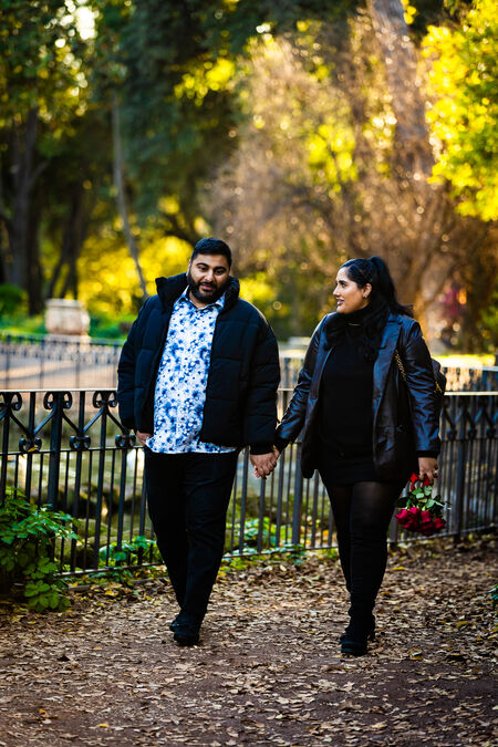 Newly-engaged couple walking by the pond in Villa Borghese during their surprise marriage proposal photo session in Rome