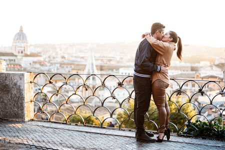 Newly-engaged couple kissing each other during their surprise proposal session at the Pincio Gardens at sunset