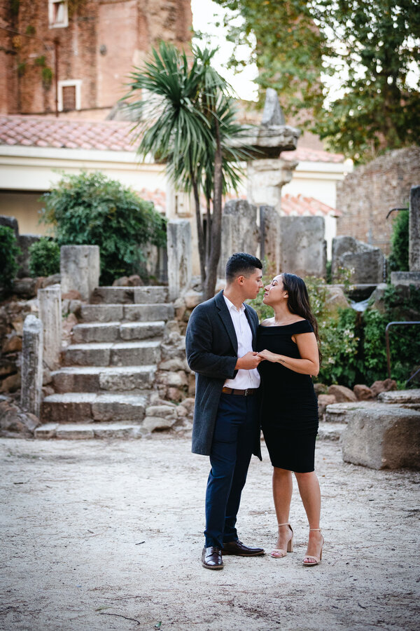 Newly-engaged couple kissing in Villa Celimontnaa during their surprise wedding proposal in Rome