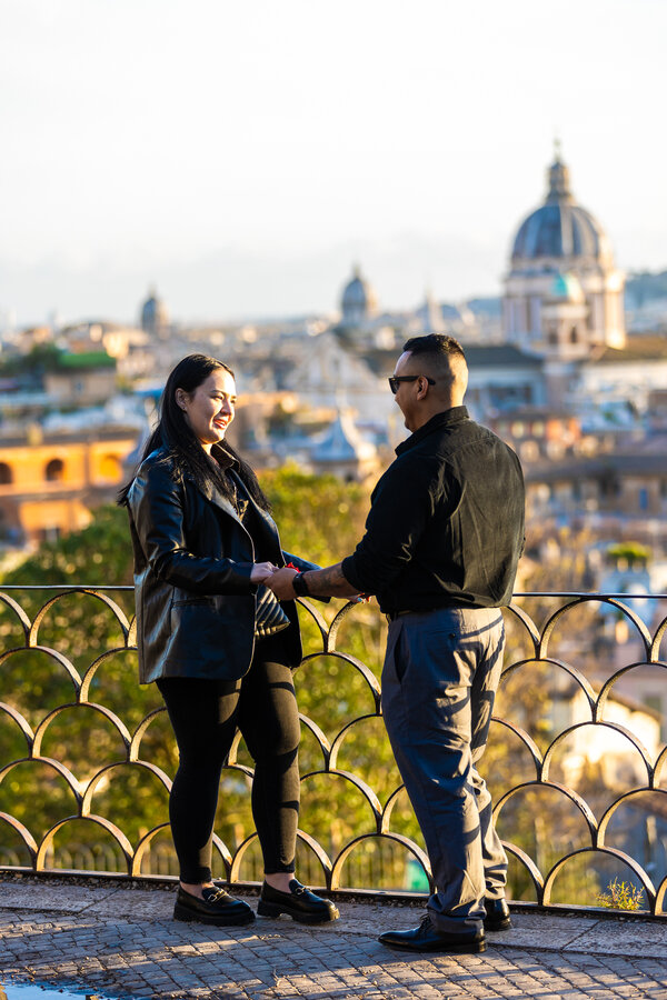 Couple holding hands in the warm light of sunset on the Pincian Hill in Rome