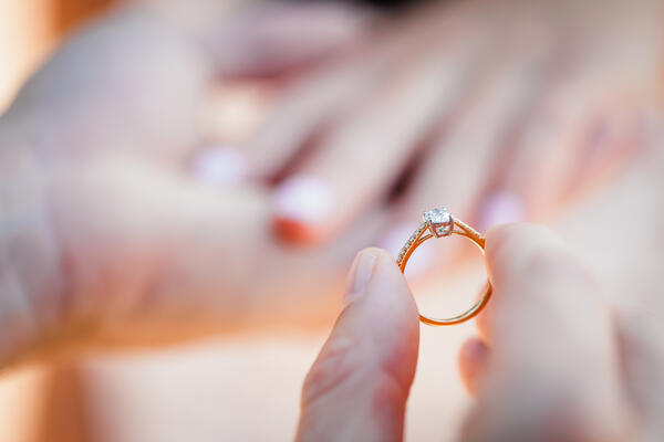 Close-up of a Tiffany diamond ring near the fiancée's hand